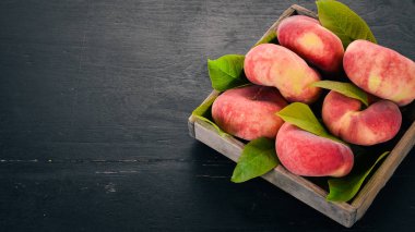 Düz şeftali mezarda. Siyah ahşap arka plan üzerinde. Üstten görünüm. Metniniz için boş alan.