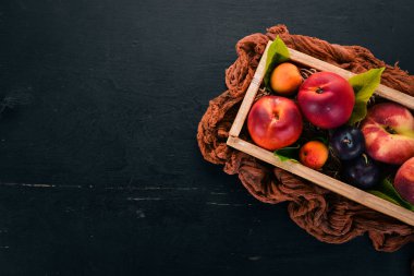 Taze meyve mezarda. Kayısı, şeftali, nektarin, Erik. Ahşap bir arka plan üzerinde. Üstten görünüm. Metniniz için boş alan.