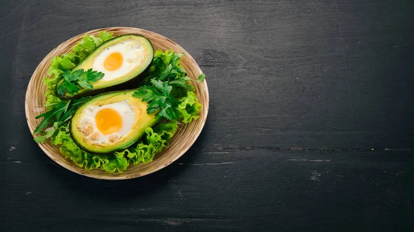 Yumurta ile pişmiş avokado. Sağlıklı gıda. Ahşap bir arka plan üzerinde. Üstten görünüm. Kopya alanı.
