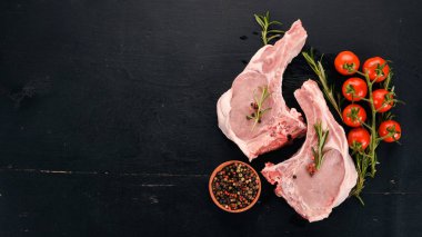 Kemik baharatlar ve sebzeler çiğ biftek. Ahşap bir arka plan üzerinde. Üstten görünüm. Kopya alanı.