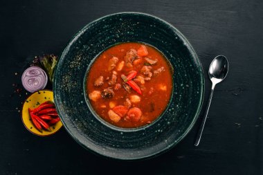 Sığır eti ve biber chervrniy plaka ile domates çorbası. Ahşap bir masaya. Üstten görünüm. Kopya alanı.