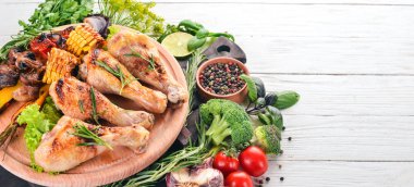 Baharatlar ve sebzeler ile pişmiş tavuk budu. Ahşap bir arka plan üzerinde. Üstten görünüm. Kopya alanı.