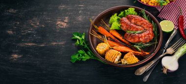Izgara sosis. Pişmiş Mısır ve patates gibiydik. Ahşap bir arka plan üzerinde. Üstten görünüm. Kopya alanı.