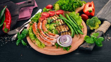 Patlıcan, fasulye ve tahta üzerinde domates ızgara sosis. Sağlıklı gıda. Siyah ahşap bir masa üzerinde. Üstten görünüm. Metin için boş alan.