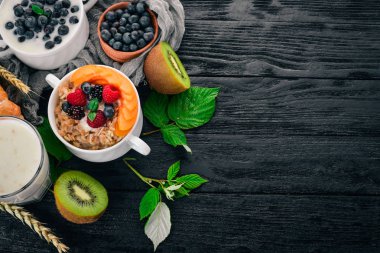 Kayısı ve yaban mersini yulaf ezmesi. Kahvaltı. Ahşap bir arka plan üzerinde. Üstten görünüm. Metin için boş alan.