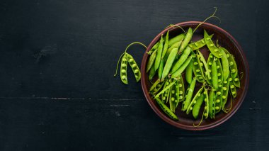 Yeşil bezelye bir ahşap plaka. Ahşap bir arka plan üzerinde. Üstten görünüm. Metniniz için boş alan.