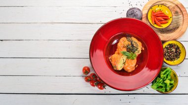 Lahana domates sosu ile kırmızı bir tabak içinde alır. Ahşap bir masaya. Üstten görünüm. Kopya alanı.