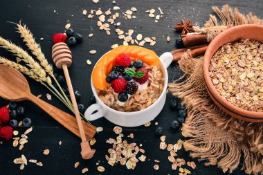 Kayısı ve yaban mersini yulaf ezmesi. Kahvaltı. Ahşap bir arka plan üzerinde. Üstten görünüm. Metin için boş alan.