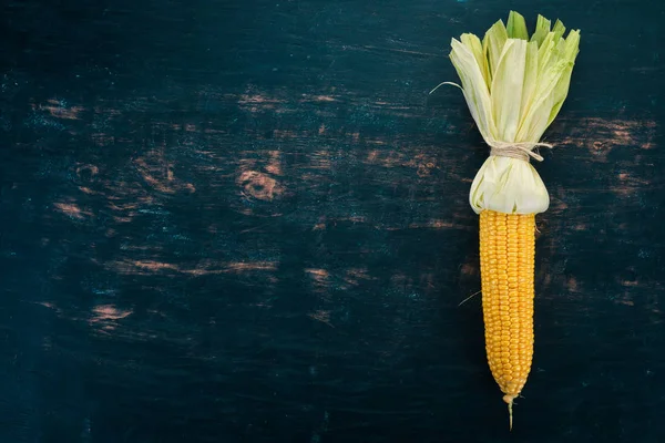 Siyah ahşap bir masa üzerinde taze sarı Mısır. Sebze. Üstten görünüm. Kopya alanı.