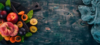 Taze meyve. Kayısı, şeftali, Erik, nektarin. Ahşap bir arka plan üzerinde. Üstten görünüm. Metniniz için boş alan.