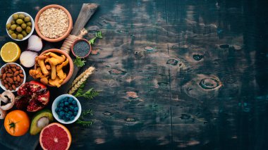 Gıda. Sebze, meyve, fındık ve çilek. Vitaminler. Eski bir ahşap masa üzerinde. Üstten görünüm. Metin için boş alan.