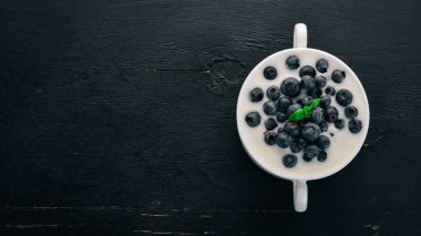 Yabanmersinli yoğurtlu. Kahvaltı. Ahşap bir arka plan üzerinde. Üstten görünüm. Metin için boş alan.