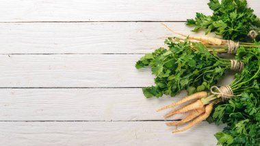 Taze yeşil maydanoz. Kök maydanoz. Ahşap bir arka plan üzerinde. Üstten görünüm. Kopya alanı.