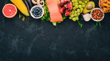 Sağlıklı gıda taş bir tablo kümesi. Balık, sebze, meyve, fındık, çilek, mantar. Üstten görünüm. Metin için boş alan.