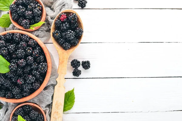 Taze çilek böğürtlen. Beyaz ahşap zemin üzerinde. Üstten görünüm. Metin için boş alan.