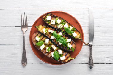 Patlıcan ızgara peynir ve fesleğen ile. Sağlıklı gıda. Beyaz ahşap bir masa üzerinde. Üstten görünüm. Metin için boş alan.