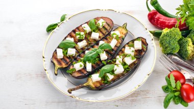 Patlıcan ızgara peynir ve fesleğen ile. Sağlıklı gıda. Beyaz ahşap bir masa üzerinde. Üstten görünüm. Metin için boş alan.