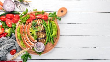 Patlıcan, fasulye ve tahta üzerinde domates ızgara sosis. Sağlıklı gıda. Beyaz ahşap bir masa üzerinde. Üstten görünüm. Metin için boş alan.