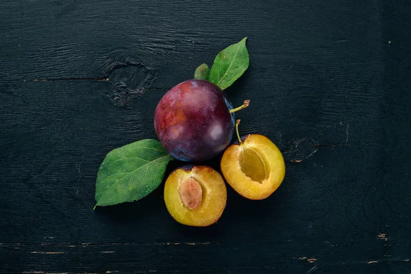 Φρέσκα Δαμάσκηνα Φύλλα Φρούτα Μαύρο Φόντο Ξύλινη Top View Ελεύθερο — Φωτογραφία Αρχείου