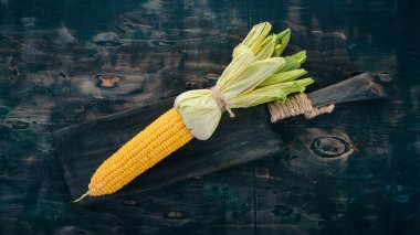 Siyah ahşap bir masa üzerinde taze sarı Mısır. Sebze. Üstten görünüm. Kopya alanı.