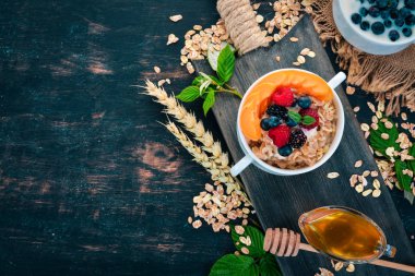 Kayısı ve yaban mersini yulaf ezmesi. Kahvaltı. Ahşap bir arka plan üzerinde. Üstten görünüm. Metin için boş alan.