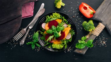 Taze pancar, domates ve marul salatası. Sağlıklı gıda. Siyah ahşap bir masa üzerinde. Üstten görünüm. Metin için boş alan.