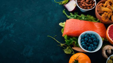 Sağlıklı gıda taş bir tablo kümesi. Balık, sebze, meyve, fındık, çilek, mantar. Üstten görünüm. Metin için boş alan.