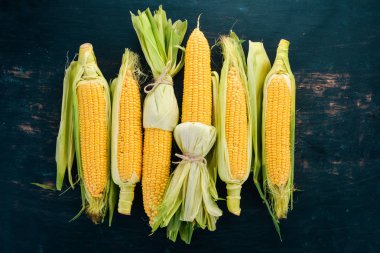 Siyah ahşap bir masa üzerinde taze sarı Mısır. Sebze. Üstten görünüm. Kopya alanı.