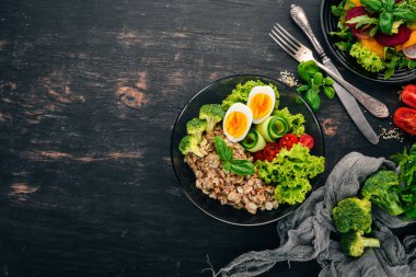 Tavuk yumurta, domates ve sebze yulaf ezmesi. Sağlıklı gıda. Siyah ahşap bir masa üzerinde. Üstten görünüm. Metin için boş alan.