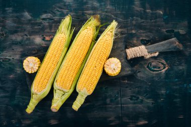 Siyah ahşap bir masa üzerinde taze sarı Mısır. Sebze. Üstten görünüm. Kopya alanı.