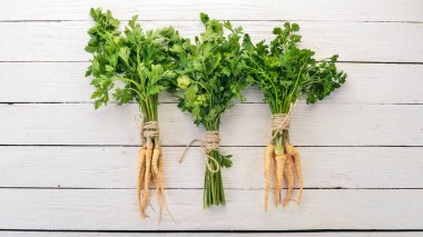 Taze yeşil maydanoz. Kök maydanoz. Ahşap bir arka plan üzerinde. Üstten görünüm. Kopya alanı.