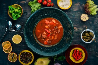 Sığır eti ve biber chervrniy plaka ile domates çorbası. Ahşap bir masaya. Üstten görünüm. Kopya alanı.