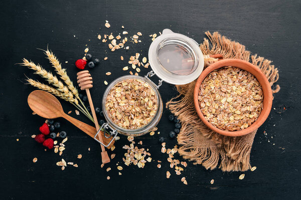Dry oatmeal porridge in a plate. Breakfast. On a wooden background. Top view. Free space for text.