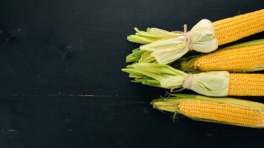 Siyah ahşap bir masa üzerinde taze sarı Mısır. Sebze. Üstten görünüm. Kopya alanı.