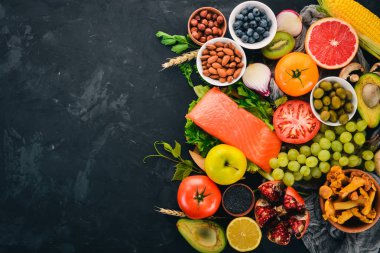Sağlıklı gıda taş bir tablo kümesi. Balık, sebze, meyve, fındık, çilek, mantar. Üstten görünüm. Metin için boş alan.