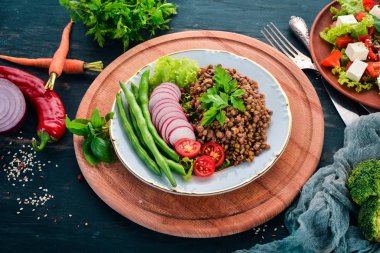 Mercimek turp, domates, fasulye ve sebze ile. Sağlıklı gıda. Siyah ahşap bir masa üzerinde. Üstten görünüm. Metin için boş alan.