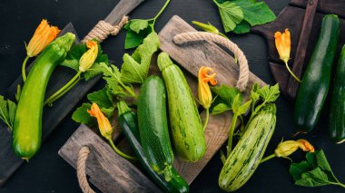 Siyah ahşap bir masa üzerinde taze yeşil kabak. Üstten görünüm. Kopya alanı.