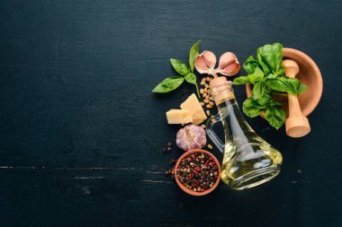 Fesleğen pesto sosu hazırlarken. Fesleğen, parmesan peyniri, zeytinyağı. Üstten görünüm. Siyah ahşap arka plan üzerinde. Metin için boş alan.