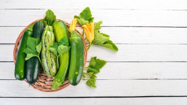 Beyaz ahşap bir masa üzerinde taze yeşil kabak. Üstten görünüm. Kopya alanı.