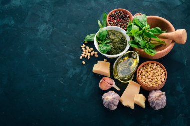 Geleneksel fesleğen pesto sos. Fesleğen, parmesan peyniri, zeytin yağı, çam fıstığı, biber, sarımsak. Üstten görünüm. Taş masanın üstünde. Metin için boş alan.