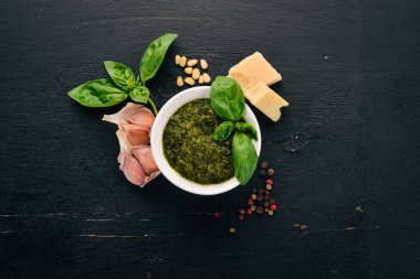 Fesleğen pesto sosu hazırlarken. Fesleğen, parmesan peyniri, zeytinyağı. Üstten görünüm. Siyah ahşap arka plan üzerinde. Metin için boş alan.