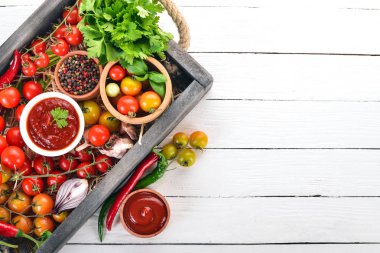 Ürün yelpazesine domates sosları mezarda. Ketçap. Kiraz domates, baharat, biber, zeytin yağı, maydanoz. Üstten görünüm.