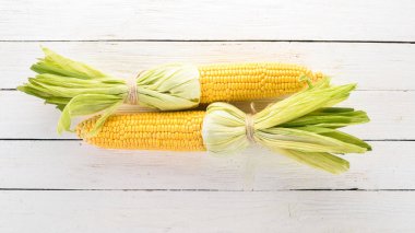Beyaz ahşap bir masa üzerinde taze sarı Mısır. Sebze. Üstten görünüm. Kopya alanı.