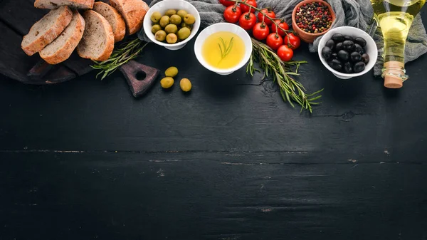一组橄榄 橄榄油 奶酪和香料 在黑色的木质背景 文本的可用空间 — 图库照片