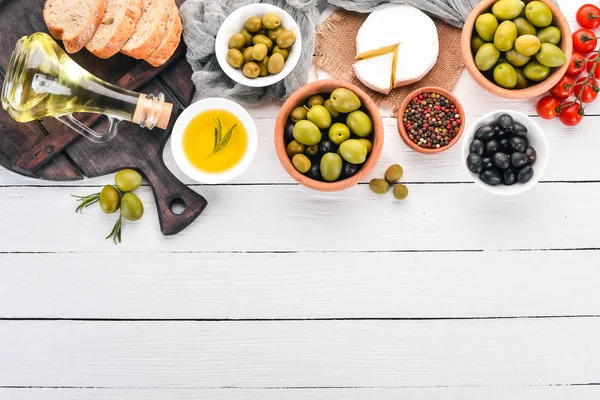 绿色橄榄和黑橄榄 乳酪和零食 意大利菜 在一个白色的木桌上 顶部视图 文本的可用空间 — 图库照片