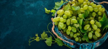 Üzüm mezarda. Üzüm yaprakları. Üstten görünüm. Siyah bir arka plan üzerinde. Metin için boş alan.