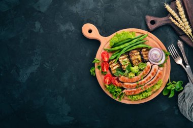 Patlıcan, fasulye ve tahta üzerinde domates ızgara sosis. Sağlıklı gıda. Taş masanın üstünde. Üstten görünüm. Metin için boş alan.