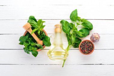 Fesleğen, baharatlar ve zeytin yağı. Üstten görünüm. Ahşap bir arka plan üzerinde. Metin için boş alan.