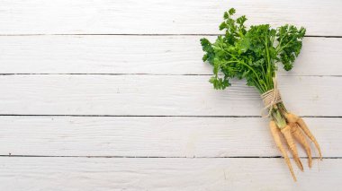 Taze yeşil maydanoz. Kök maydanoz. Ahşap bir arka plan üzerinde. Üstten görünüm. Kopya alanı.