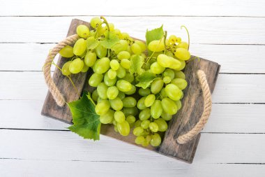 Üzüm. Beyaz ahşap zemin üzerinde taze beyaz üzüm. Üstten görünüm. Metin için boş alan.